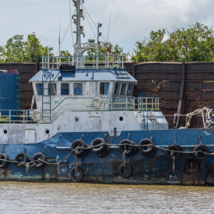 Blue and white tugboat moored alongside a rusty barge, close view, Maratua, Kalimantan (Borneo), Indonesia