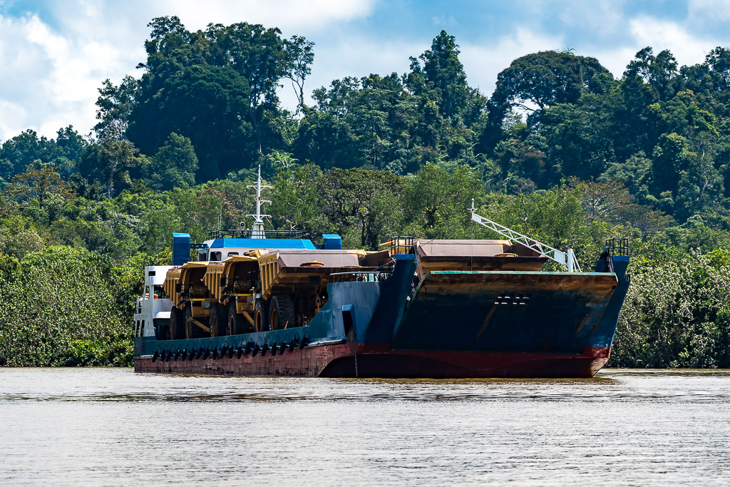 Landing craft carrying giant yellow mining dump trucks, bow view, Maratua, Kalimantan (Borneo), Indonesia