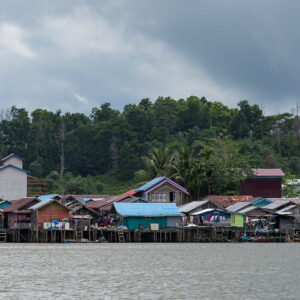 Stilt village waterfront under a dark stormy sky, wide view, Maratua, Kalimantan (Borneo), Indonesia