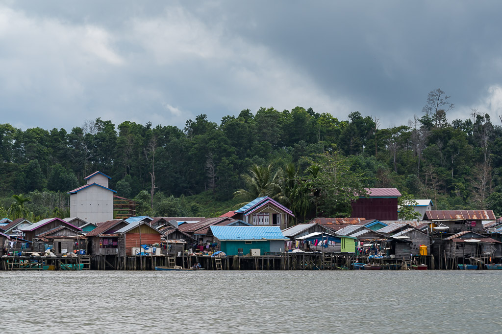 Stilt village waterfront under a dark stormy sky, wide view, Maratua, Kalimantan (Borneo), Indonesia
