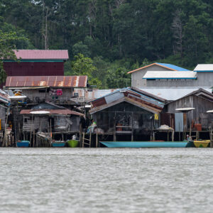 Stilt houses with colourful moored boats along the shore, Maratua, Kalimantan (Borneo), Indonesia