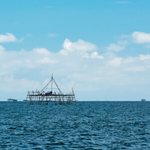 Distant bamboo bagang fishing platform on a deep blue sea horizon, Maratua, Kalimantan (Borneo), Indonesia