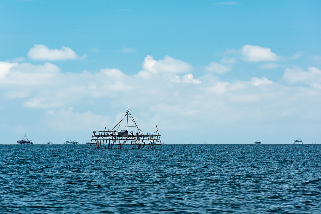 Distant bamboo bagang fishing platform on a deep blue sea horizon, Maratua, Kalimantan (Borneo), Indonesia