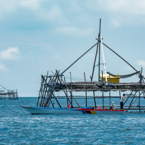 Fishermen with boats moored at a bagang platform, second one in distance, Maratua, Kalimantan (Borneo), Indonesia