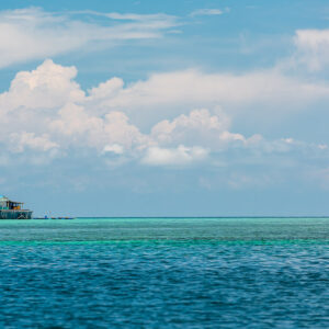 Small stilt hut on a turquoise lagoon under cumulus clouds, Maratua, Kalimantan (Borneo), Indonesia