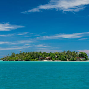 Small forested islet on a turquoise lagoon under streaked clouds, Maratua, Kalimantan (Borneo), Indonesia