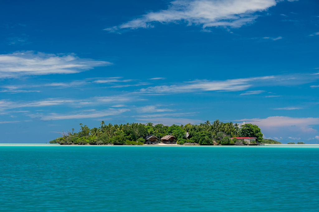 Petit îlot boisé sur un lagon turquoise sous des nuages effilés, Maratua, Kalimantan (Bornéo), Indonésie