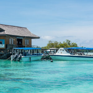 Dive centre jetty building with two dive boats moored on turquoise water, Maratua, Kalimantan (Borneo), Indonesia