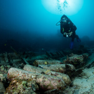Diver facing the camera above a wooden wreck with scuba tanks, Maratua, Kalimantan (Borneo), Indonesia