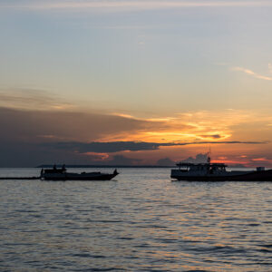 Two boats silhouetted on the sea at dusk under dramatic clouds, Maratua, Kalimantan (Borneo), Indonesia