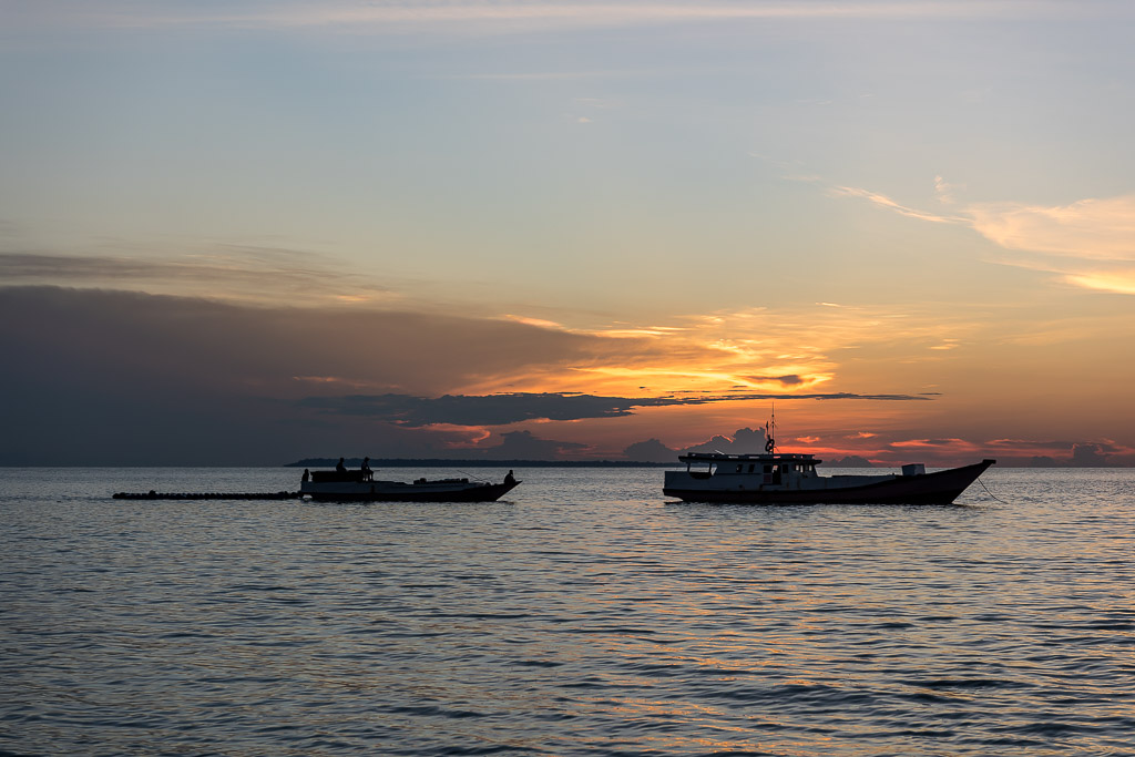 Deux bateaux en silhouette sur la mer au crépuscule sous des nuages spectaculaires, Maratua, Kalimantan (Bornéo), Indonésie