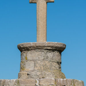 Close-up of granite cross atop round stone column against blue sky, Le Croisic, Brittany, France
