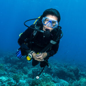 Woman diver portrait facing the camera above the reef, Misool, Raja Ampat, Indonesia