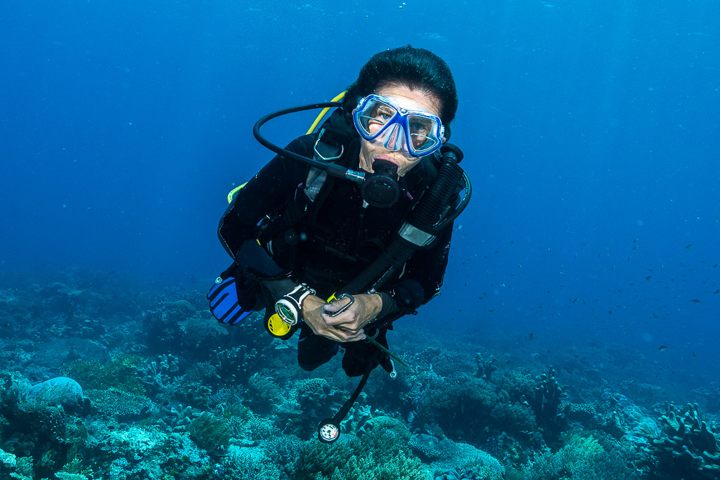 Woman diver portrait facing the camera above the reef, Misool, Raja Ampat, Indonesia