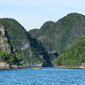 Steep forested karst peaks rising on both sides of a channel, Misool, Raja Ampat, Indonesia