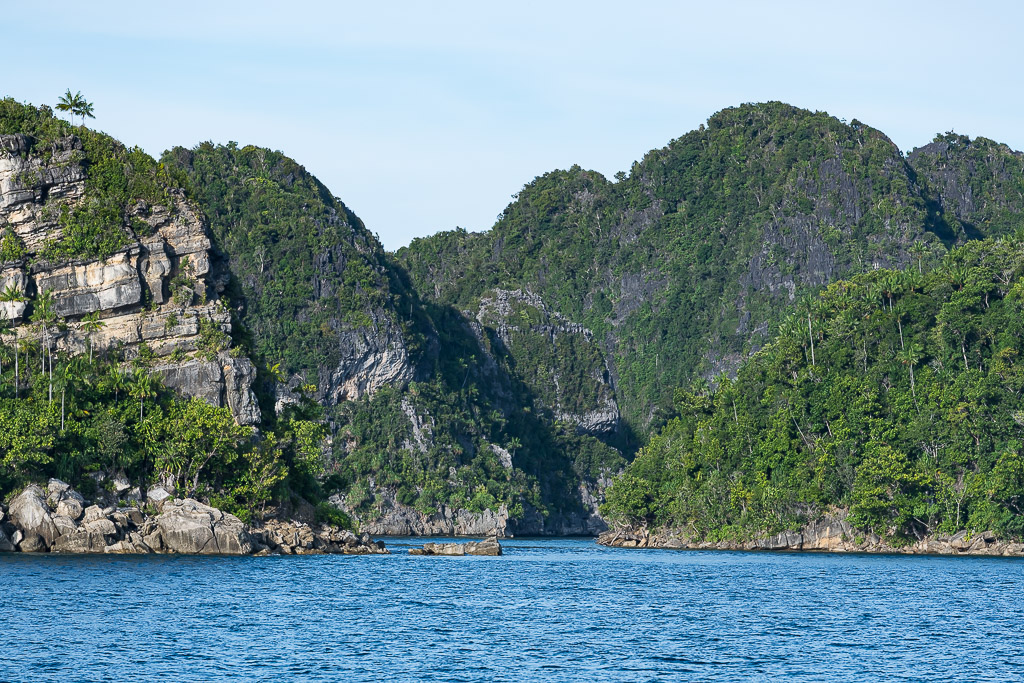 Steep forested karst peaks rising on both sides of a channel, Misool, Raja Ampat, Indonesia