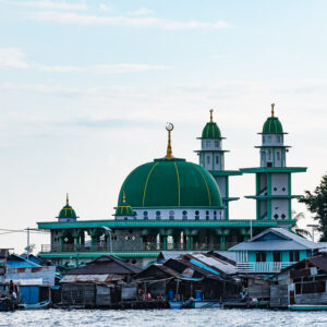 Green-domed mosque with twin minarets above stilt houses, Misool, Raja Ampat, Indonesia