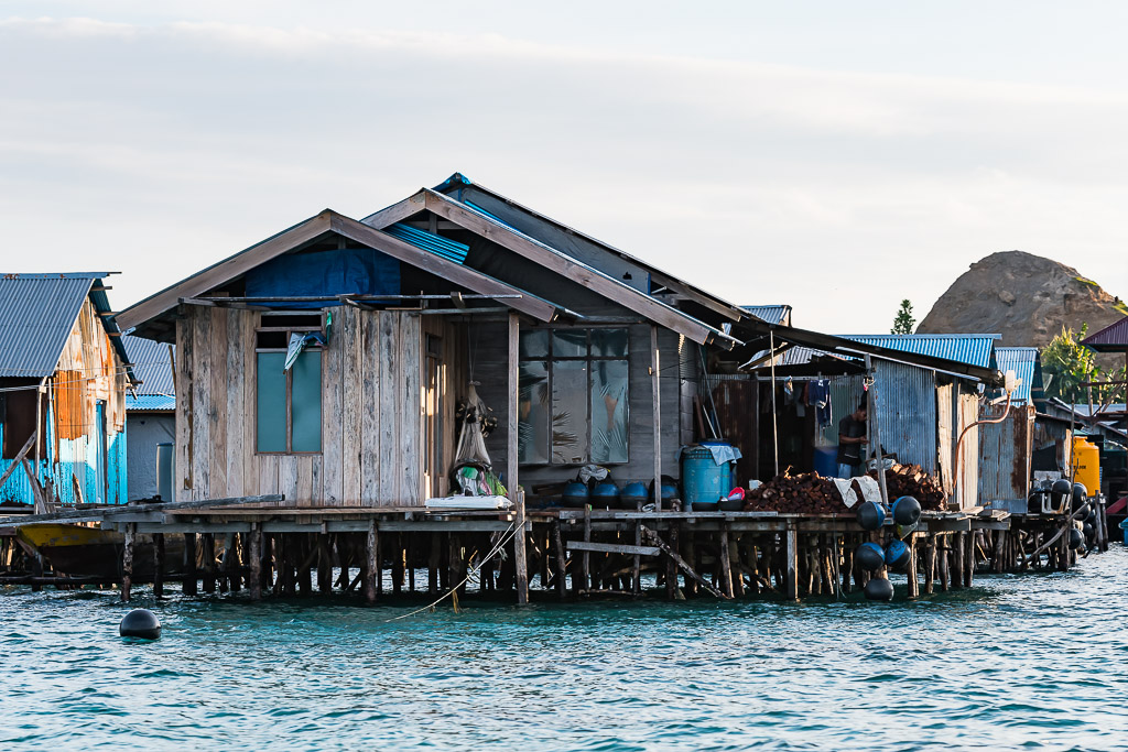 Vieille maison en bois sur pilotis aux planches grises, bouée devant, Misool, Raja Ampat, Indonésie