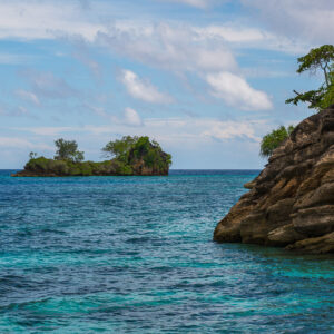 Rocky headland on the right with a small islet across turquoise water, Misool, Raja Ampat, Indonesia