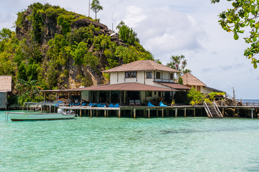 Bâtiment principal d’hôtel sur pilotis devant une falaise calcaire, Misool, Raja Ampat, Indonésie