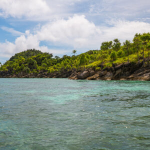 Longue île rocheuse basse bordée de pandanus au-dessus de hauts-fonds clairs, Misool, Raja Ampat, Indonésie