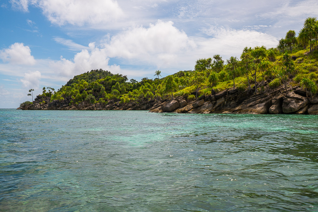 Longue île rocheuse basse bordée de pandanus au-dessus de hauts-fonds clairs, Misool, Raja Ampat, Indonésie