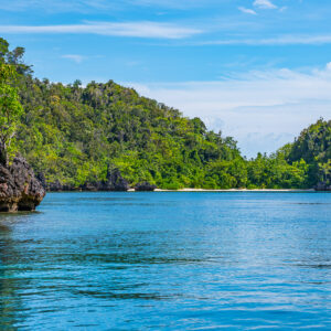 Jungle-covered islands with a hidden white beach between cliffs, Misool, Raja Ampat, Indonesia