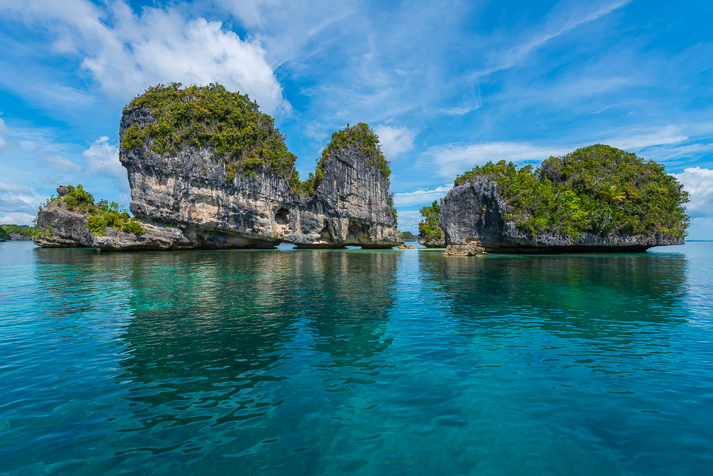 Karst islets and their reflections on a mirror-calm sea, Misool, Raja Ampat, Indonesia