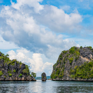 Narrow passage between karst islets with a tiny rock, vertical, Misool, Raja Ampat, Indonesia
