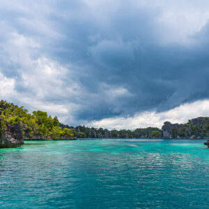 Turquoise passage between karst islands under dark storm clouds, Misool, Raja Ampat, Indonesia