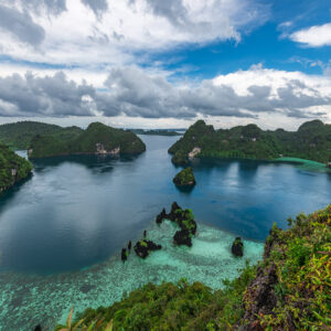 Vue d’un belvédère sur un lagon bleu profond avec pitons karstiques et récif, Misool, Raja Ampat, Indonésie