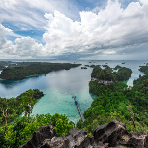 Karst islands and lagoon with a jetty below, dramatic clouds, Misool, Raja Ampat, Indonesia