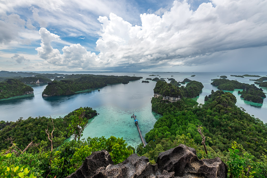 Îles karstiques et lagon avec un ponton en contrebas, nuages spectaculaires, Misool, Raja Ampat, Indonésie