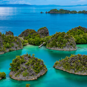 Rounded limestone islets in turquoise water with distant islands, Waigeo, Raja Ampat, Indonesia