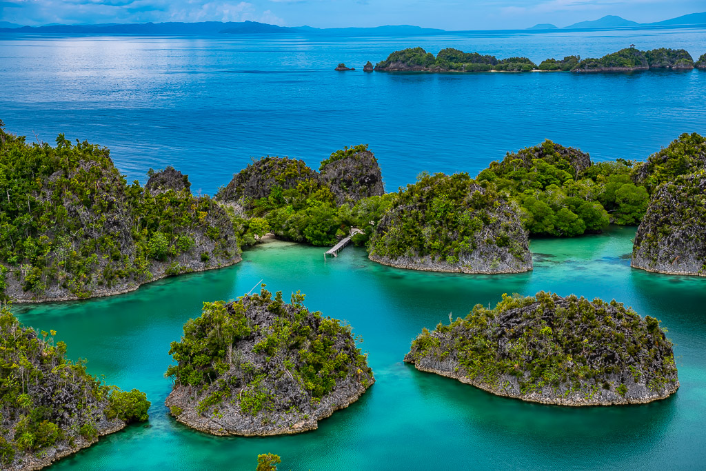 Rounded limestone islets in turquoise water with distant islands, Waigeo, Raja Ampat, Indonesia