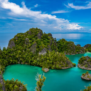 Jagged karst island and small islets in a turquoise lagoon, Waigeo, Raja Ampat, Indonesia