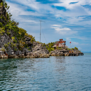 Stilt house on a rocky point jutting into the sea, Raja Ampat, Indonesia