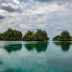 Alignement d’îlots en champignon reflétés dans un lagon turquoise calme, Waigeo, Raja Ampat, Indonésie