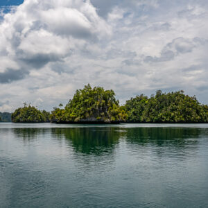 Cluster of jungle islets on the horizon of a silver lagoon, Waigeo, Raja Ampat, Indonesia