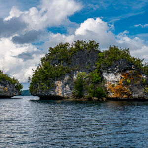 Large eroded islet with orange cliffs beside a small rock stack, Waigeo, Raja Ampat, Indonesia
