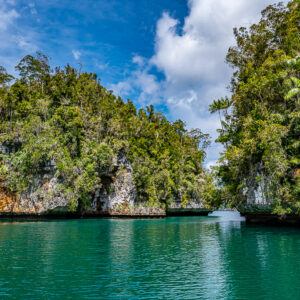 Jungle islets with orange-streaked cliffs over emerald water, Waigeo, Raja Ampat, Indonesia