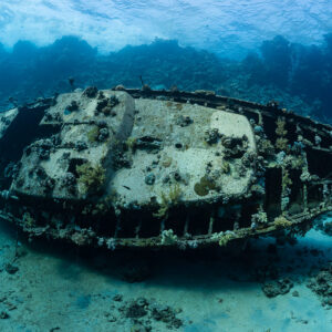 Wreck of a metal sailboat lying on its side on a sandy reef, Red Sea, Egypt