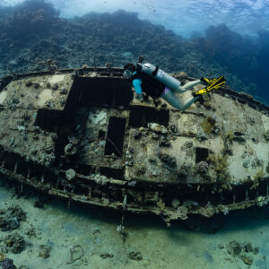 Woman diver above the deck of a sailboat wreck, wider view, Red Sea, Egypt
