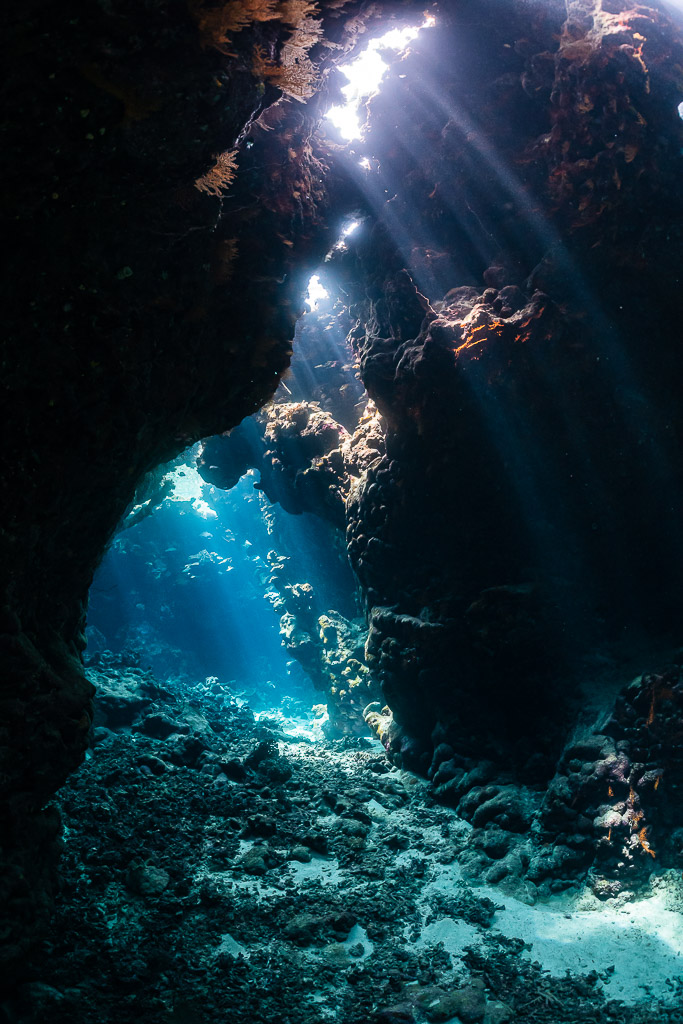 Rayons de soleil tombant d’une arche de grotte sur un fond de sable, sans plongeur, grottes de St John's, mer Rouge, Égypte