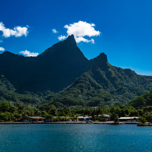 Jagged green volcanic peaks above a bay and shoreline houses, Moorea, Society Islands, French Polynesia