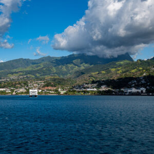 Waterfront town at the foot of cloud-covered peaks seen from the sea, Tahiti, Society Islands, French Polynesia