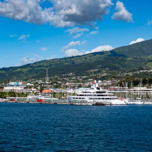 Marina with sailboats and a large white yacht below green hills, Tahiti, Society Islands, French Polynesia