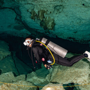 Cavern diver following the guideline above limestone boulders in a cenote, Quintana Roo, Mexico