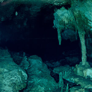 Stalactites and a stalagmite column rising from boulders in a cenote cavern, Quintana Roo, Mexico