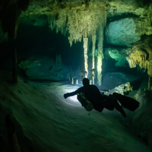 Vue verticale d’un plongeur passant entre des colonnes de stalactites, Quintana Roo, Mexique